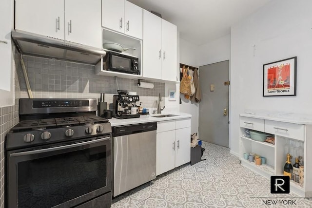 kitchen featuring stainless steel appliances, under cabinet range hood, light countertops, a sink, and white cabinets