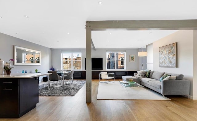 living room featuring light wood-style floors, recessed lighting, and beam ceiling