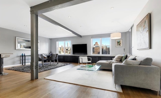 living room featuring wood finished floors, beam ceiling, and baseboards