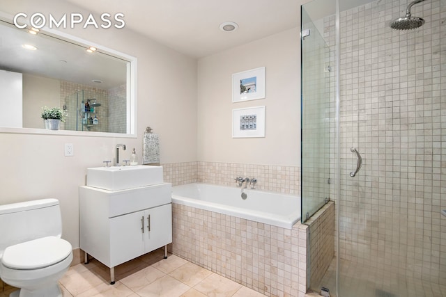 full bath featuring a stall shower, tile patterned floors, a bath, toilet, and vanity