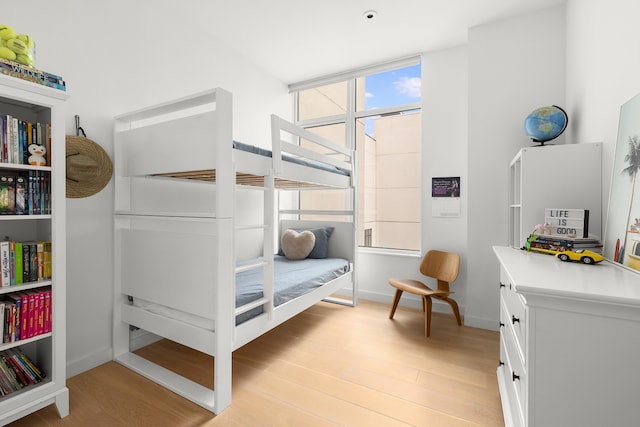 bedroom with baseboards and light wood finished floors