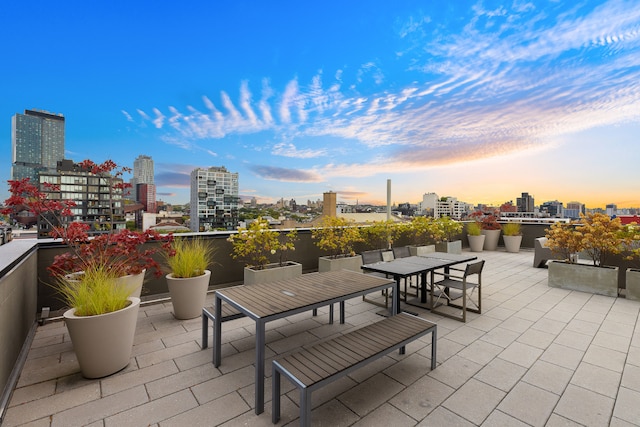 patio terrace at dusk with a city view and outdoor dining area