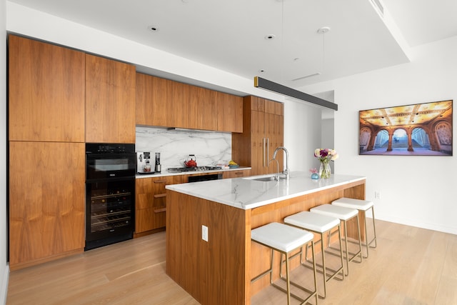 kitchen with brown cabinets, beverage cooler, a sink, and modern cabinets