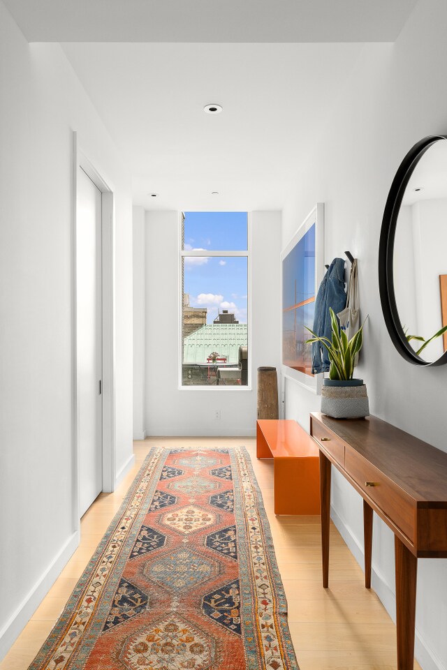 hallway with baseboards and wood finished floors