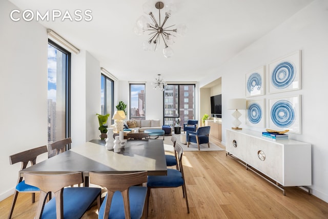 360 E 89th St Unit 29B, New York City, NY 10128 - dining room featuring a chandelier, light wood-style flooring, and baseboards