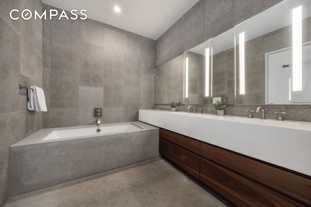 360 E 89th St Unit 29B, New York City, NY 10128 - full bathroom with tile walls, a bath, double vanity, and tile patterned flooring