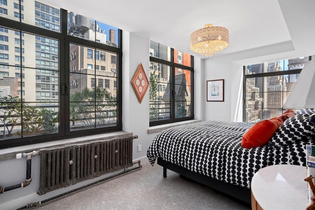 360 W 36th St Unit Ph12, New York City, NY 10018 - bedroom with radiator, a chandelier, and a view of city