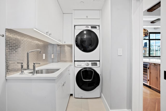 360 W 36th St Unit Ph12, New York City, NY 10018 - laundry room featuring stacked washer / drying machine, wine cooler, and cabinet space