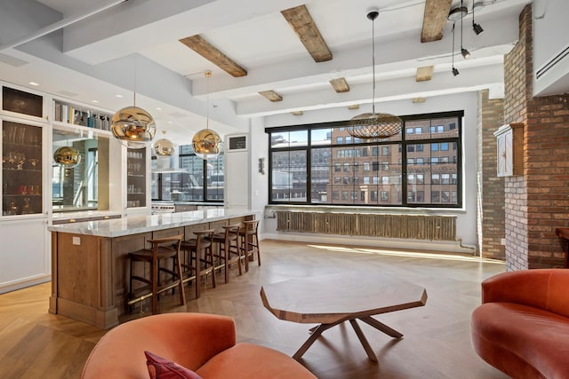 360 W 36th St Unit Ph12, New York City, NY 10018 - bar with radiator heating unit, beamed ceiling, decorative light fixtures, and brick wall