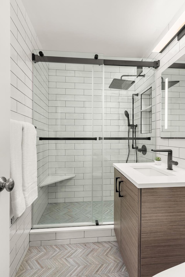 full bath featuring a shower stall, vanity, and tile walls