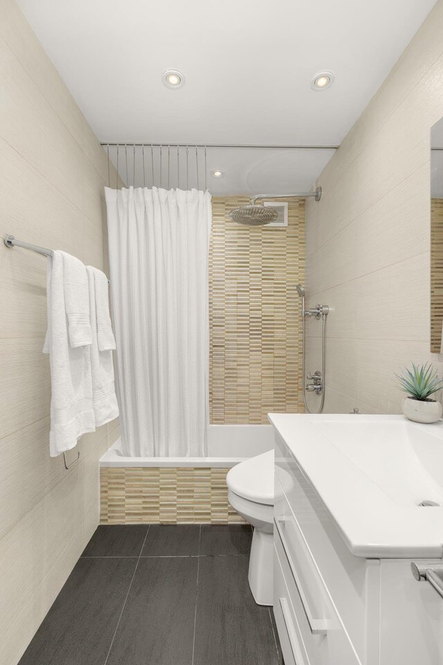 230 E 79th St Unit 12Cd, New York City, NY 10021 - full bath featuring tiled shower / bath, recessed lighting, toilet, tile patterned floors, and vanity