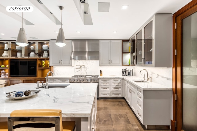 159 E 61st St, New York City, NY 10065 - kitchen featuring wall chimney exhaust hood, a sink, light stone counters, and recessed lighting