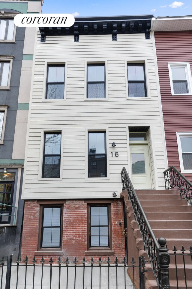 16 Goodwin Place, New York City, NY 11221 - view of front of house with brick siding and a fenced front yard