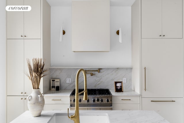 16 Goodwin Place, New York City, NY 11221 - kitchen featuring tasteful backsplash, light stone counters, white cabinets, and stainless steel range with gas stovetop