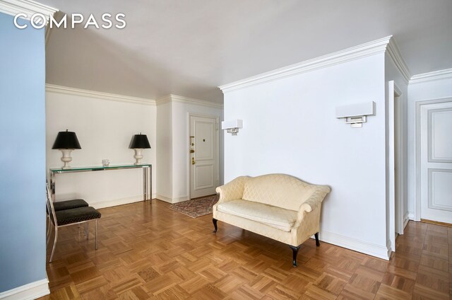 living area with baseboards and ornamental molding