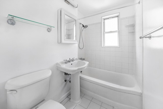 full bathroom featuring toilet, tile patterned floors, and  shower combination
