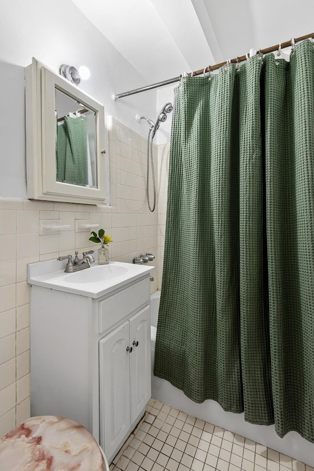 full bathroom featuring tile patterned floors, vanity, shower / tub combo with curtain, and tile walls