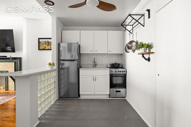 kitchen with stainless steel appliances, a sink, decorative backsplash, and light countertops