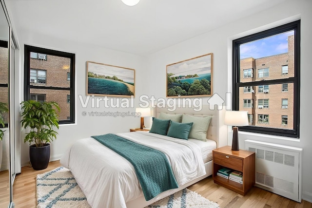 4489 Broadway Unit 5E, New York City, NY 10040 - bedroom featuring radiator heating unit and light wood finished floors