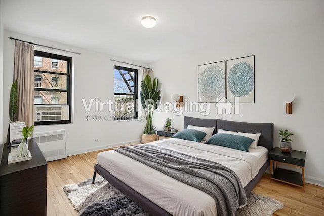4489 Broadway Unit 5E, New York City, NY 10040 - bedroom featuring radiator, light wood finished floors, and cooling unit