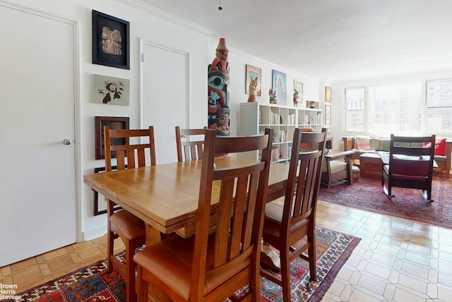 dining area with tile patterned floors and crown molding