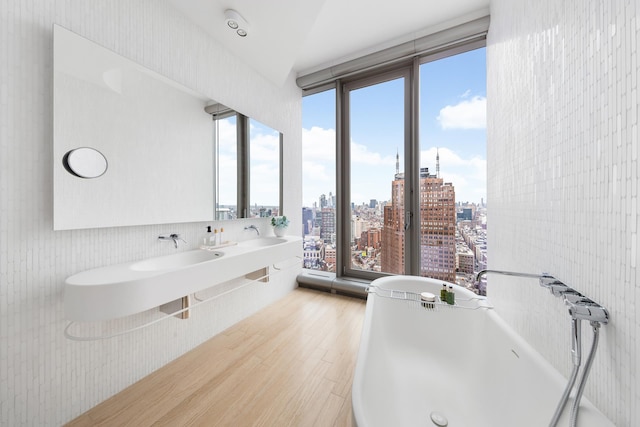 56 Leonard St Unit 29Ae, New York City, NY 10013 - bathroom with wood finished floors, a freestanding bath, and a city view