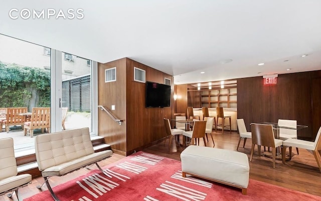 living room with wood finished floors and wooden walls