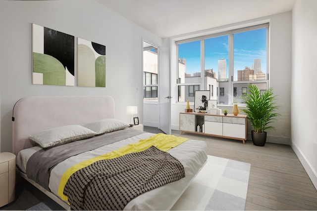 bedroom with wood finished floors, baseboards, and a view of skyline