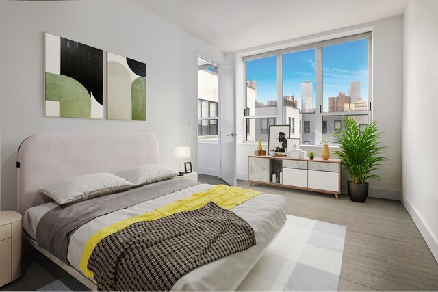 416 W 52nd St Unit 704, New York City, NY 10019 - bedroom with wood finished floors, baseboards, and a skyline view