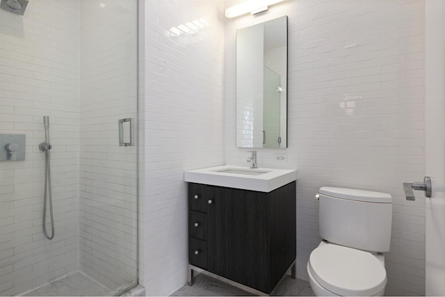 bathroom featuring a shower stall, toilet, tile walls, and vanity