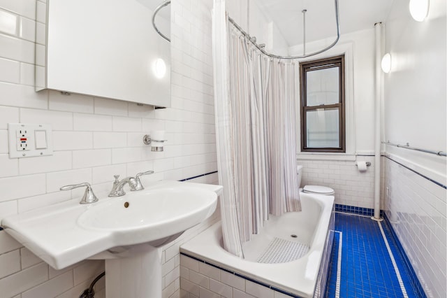 bathroom with tile walls, a tub, tile patterned floors, a sink, and a tile shower