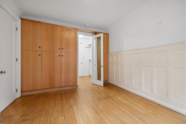 unfurnished bedroom with light wood finished floors and a closet