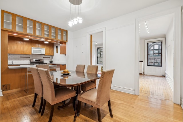 dining space featuring baseboards and light wood-type flooring