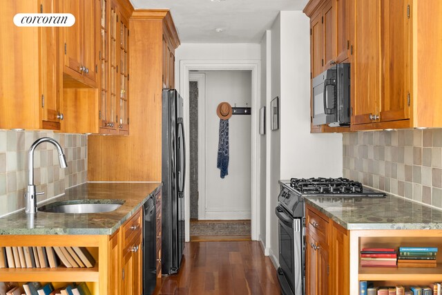 116 Pinehurst Ave Unit R21, New York City, NY 10033 - kitchen featuring black appliances, brown cabinetry, dark stone countertops, and dark wood-style flooring