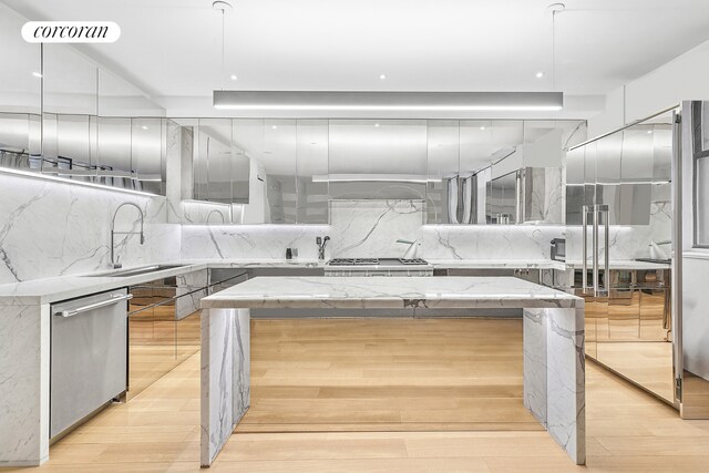 kitchen featuring tasteful backsplash, stainless steel dishwasher, a kitchen island, a sink, and modern cabinets