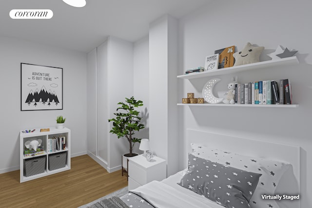 bedroom featuring wood finished floors, visible vents, and baseboards