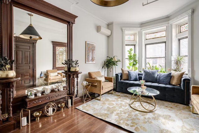 living area with a wall unit AC, crown molding, and wood finished floors