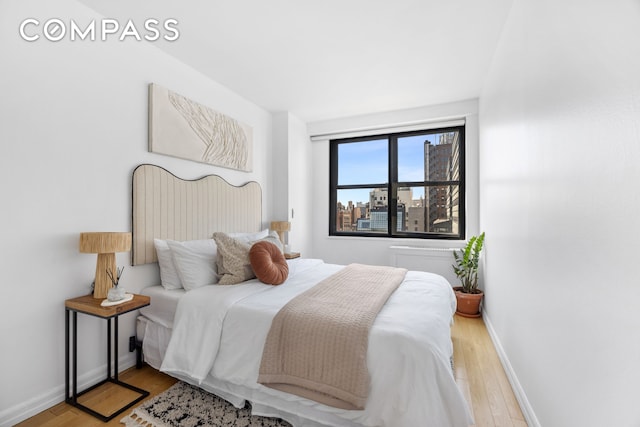 bedroom featuring light wood-style floors and baseboards