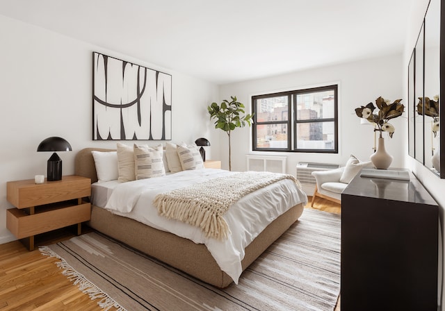 140 7th Ave Unit 4L, New York City, NY 10011 - bedroom with light wood-type flooring and a wall unit AC