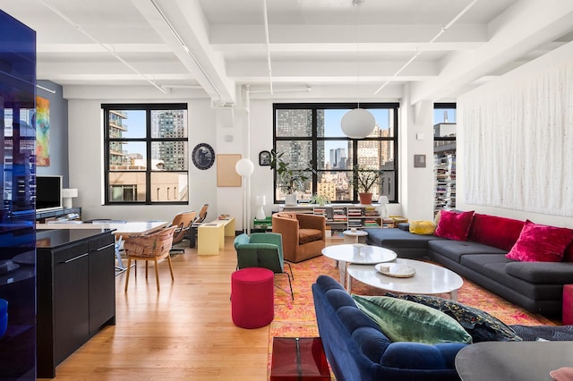 448 W 37th St Unit 9A, New York City, NY 10018 - living area with light wood-type flooring and beam ceiling