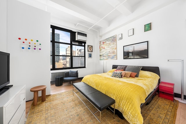 448 W 37th St Unit 9A, New York City, NY 10018 - bedroom with radiator and wood finished floors