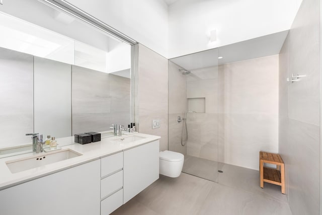 448 W 37th St Unit 9A, New York City, NY 10018 - bathroom featuring a walk in shower, double vanity, and tile walls