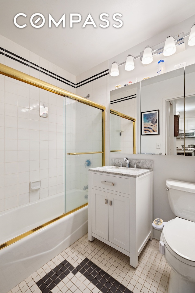 22 W 15th St Unit 10G, New York City, NY 10011 - bathroom featuring tile patterned flooring, toilet, vanity, and enclosed tub / shower combo
