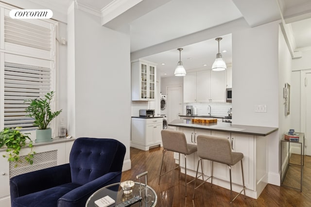 240 W 98th St Unit 3D, New York City, NY 10025 - kitchen with stacked washing machine and dryer, a sink, dark wood finished floors, white cabinets, and glass insert cabinets