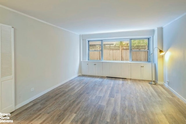 330 E 49th St Unit 3L, New York City, NY 10017 - empty room featuring wood finished floors, baseboards, and crown molding