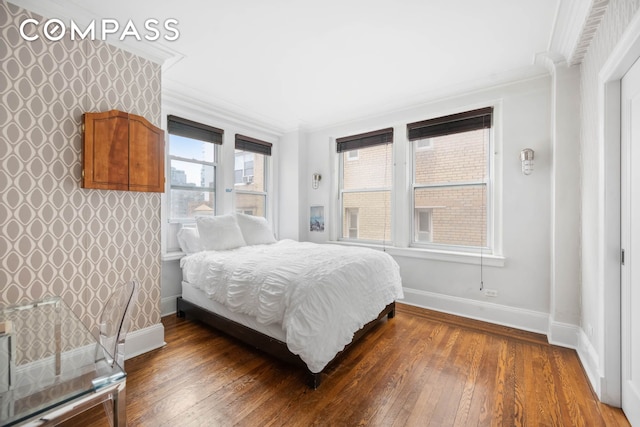 bedroom with baseboards, wood-type flooring, and crown molding