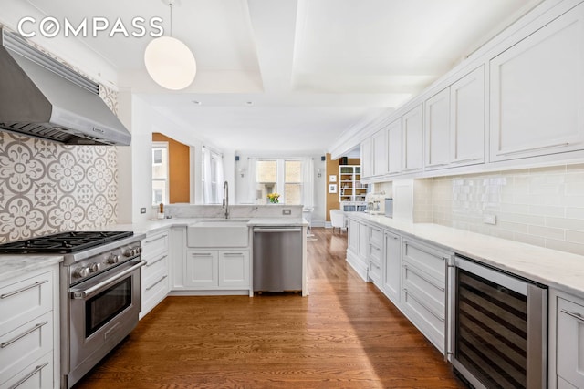 136 E 36th St Unit 9/10C, New York City, NY 10016 - kitchen featuring wine cooler, appliances with stainless steel finishes, a sink, ventilation hood, and wood finished floors