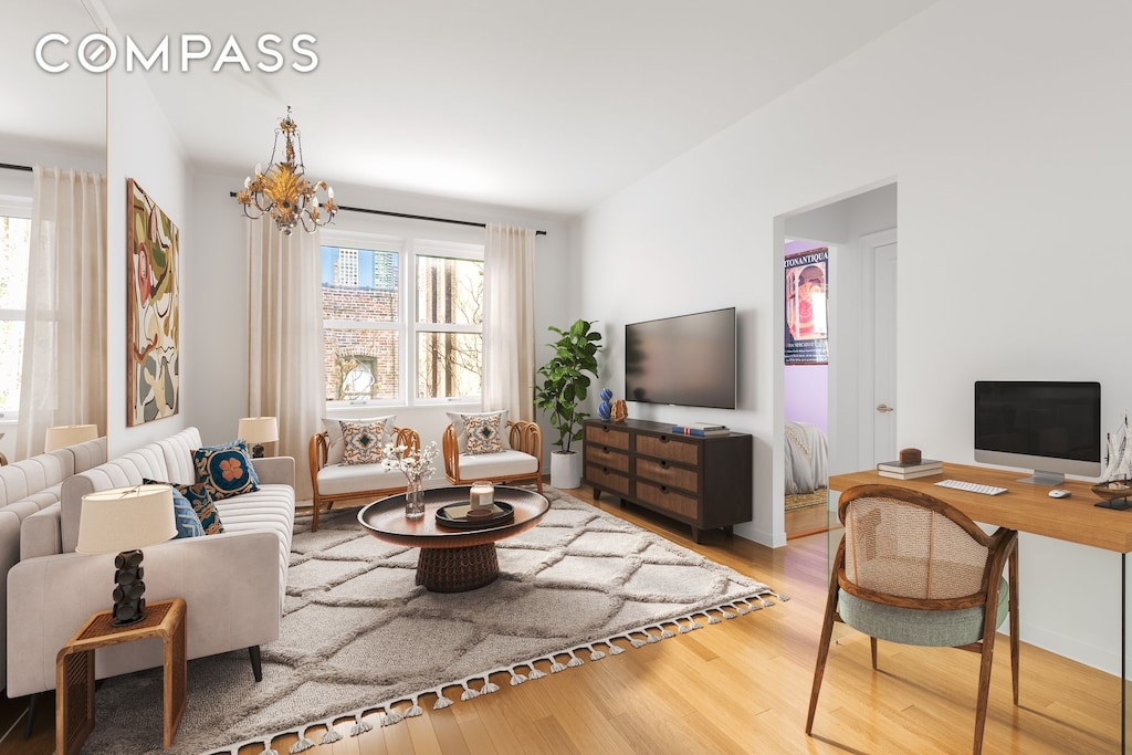 living room featuring plenty of natural light, wood finished floors, and a chandelier