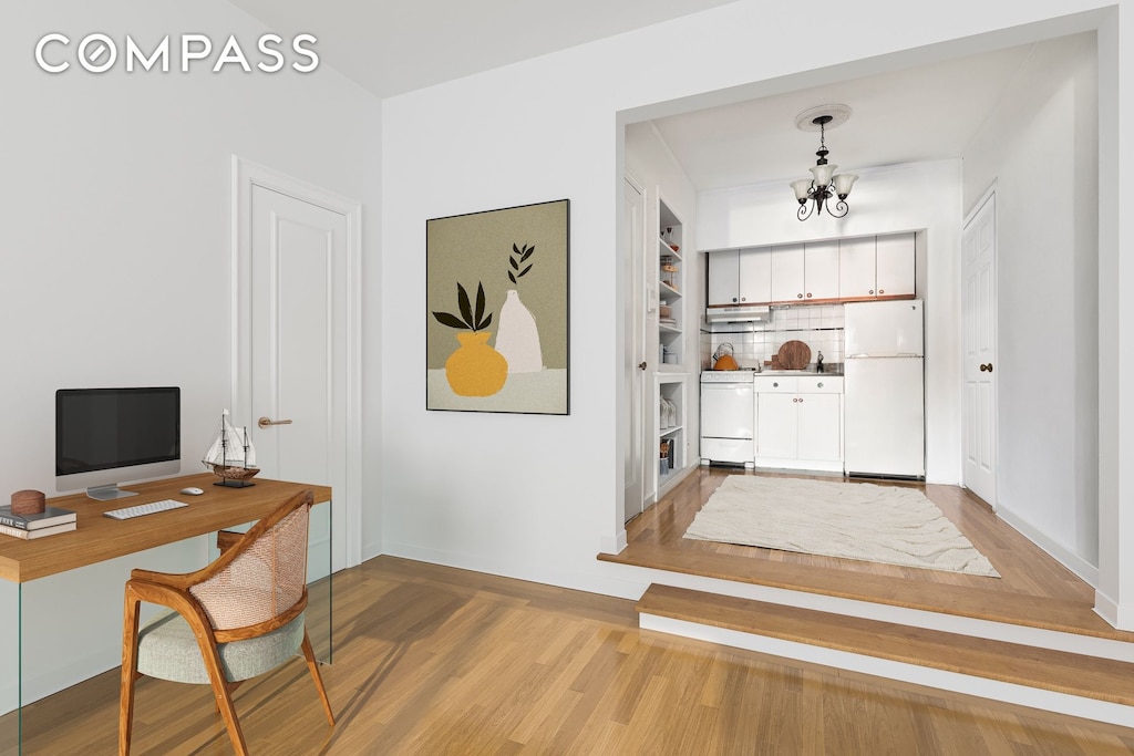 225 E 47th St Unit 6H, New York City, NY 10017 - office area featuring light wood-style flooring, a chandelier, and baseboards