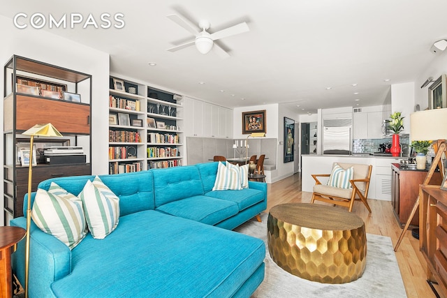 living room featuring ceiling fan, light wood-type flooring, and recessed lighting
